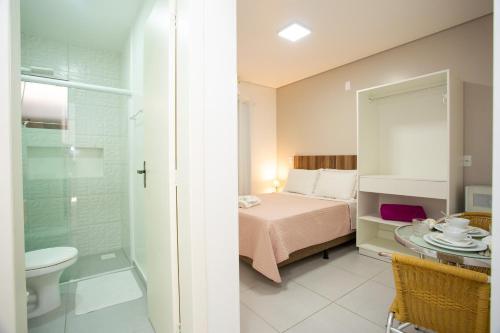 a bedroom with a bed and a bathroom at Pousada Doce Encanto in Florianópolis