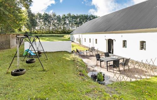 a white building with a table and a swing at Beautiful Home In Grenaa With Wifi in Grenå