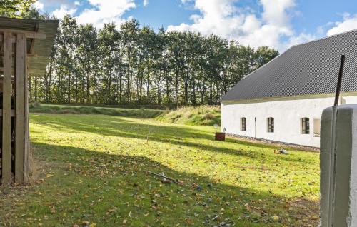 a white barn with a grass field next to it at Beautiful Home In Grenaa With Wifi in Grenå