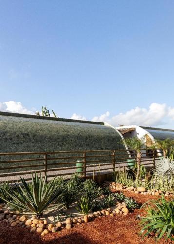 a garden with a fence and plants in front of a building at Filho do Vento Kite & Lodge in Canguaretama