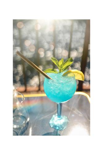 a blue drink sitting on top of a table at Hotel Restaurant du Parc en Bord de Rivière in Fontaine-de-Vaucluse