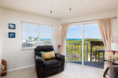 a living room with a chair and a balcony at Flamingo Flats Ocean Pointe 5306 in Key Largo
