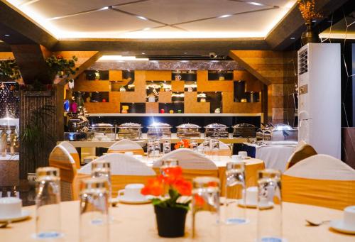 a dining room with tables and chairs with flowers on them at Coral Reef Hotel & Spa, Port Blair in Port Blair