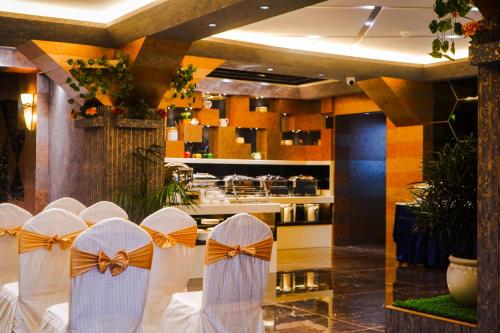 a row of chairs with bows in a restaurant at Coral Reef Hotel & Spa, Port Blair in Port Blair
