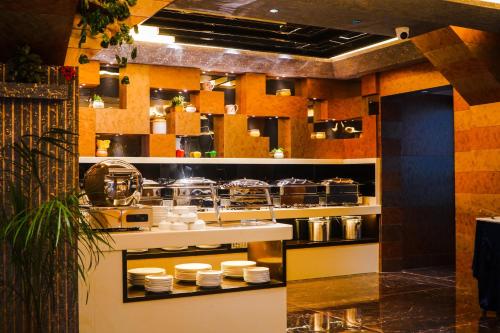 a kitchen with white dishes on a counter at Coral Reef Hotel & Spa, Port Blair in Port Blair
