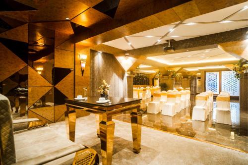 a banquet hall with a table and white chairs at Coral Reef Hotel & Spa, Port Blair in Port Blair