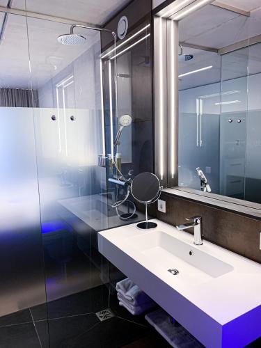 a bathroom with a sink and a mirror at Hotel Zeitgeist Warburg KG in Warburg
