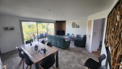 un salon avec une table et des chaises en bois dans l'établissement T4 Familial dans résidence calme à proximité de la mer, à Cavalaire-sur-Mer