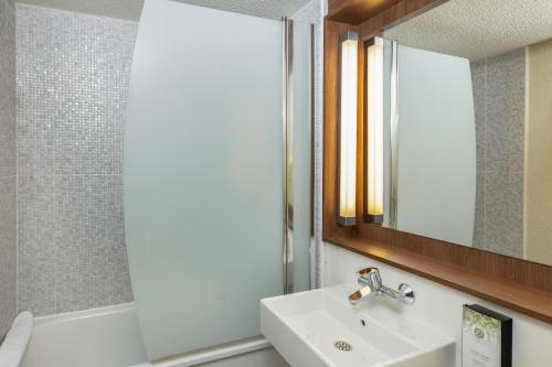 a bathroom with a sink and a mirror at Campanile NATURE - Cergy Saint Christophe in Cergy