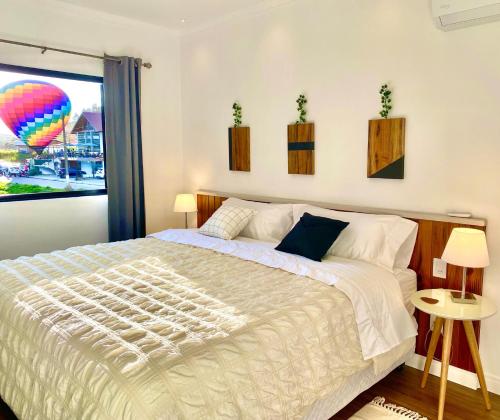 a bedroom with a large bed with a hot air balloon at Vila Broussard Flats Centro Pedra Azul in Pedra Azul