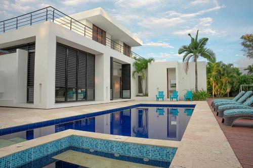 a villa with a swimming pool in front of a house at Iguá Casas de Campo - Anapoima in Anapoima