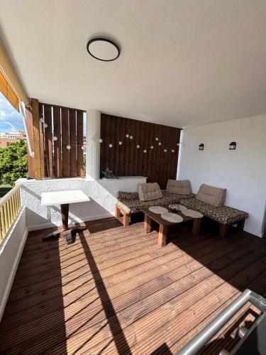 a living room with a deck with a couch and tables at Apartamento los jazmines in Roquetas de Mar