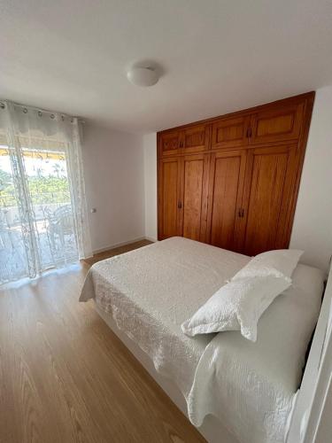 a bedroom with a white bed and a window at Apartamento los jazmines in Roquetas de Mar