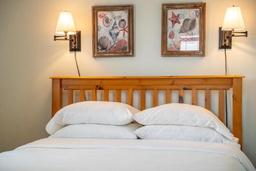 a bed with two pillows and two pictures on the wall at Shangri-La Cottages in Burntcoat