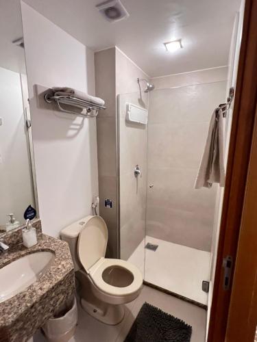 a bathroom with a toilet and a sink and a shower at Nobile Suites, Flats Rocha in Brasília