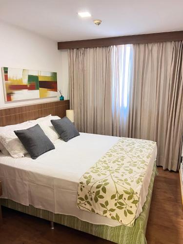 a bedroom with a large bed and a window at Nobile Suites, Flats Rocha in Brasília