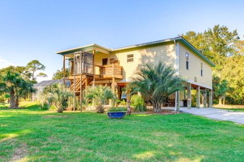 a large yellow house with a balcony and a yard at Waterfront Gulf Coast Home with Outdoor Oasis! in Gautier