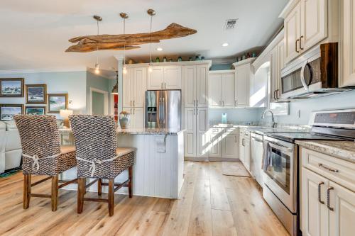 a kitchen with white cabinets and a table and chairs at Waterfront Gulf Coast Home with Outdoor Oasis! in Gautier