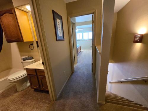 a hallway of a bathroom with a toilet and a sink at Grisham's View Condo: Central Condo with a Golf Course View! in Ruidoso