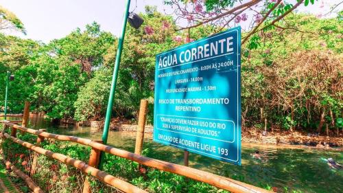 a sign in front of a fence with a river at Apartamento de 4 Quartos Cobertura Com Área de Lazer in Rio Quente