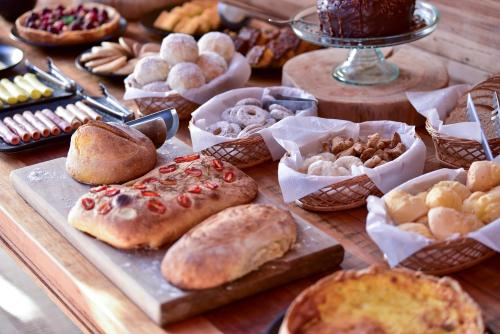a table topped with different types of pastries and cakes at Parque Nacional EcoResort in Urubici