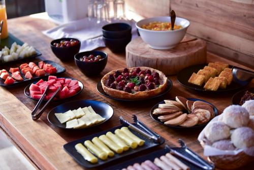 a table filled with different types of food on plates at Parque Nacional EcoResort in Urubici
