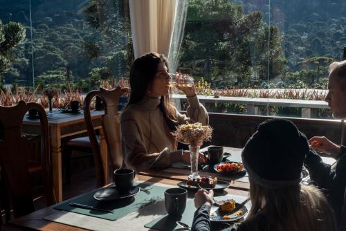 a group of people sitting around a table drinking wine at Parque Nacional EcoResort in Urubici