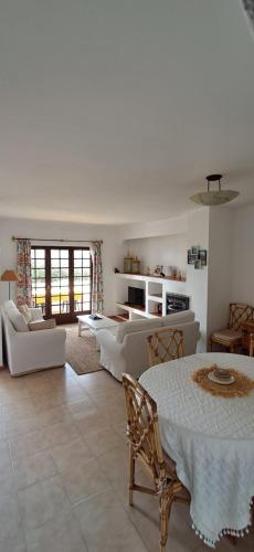 a living room with a table and chairs and a living room at Apartamento Neptuno in Benagil