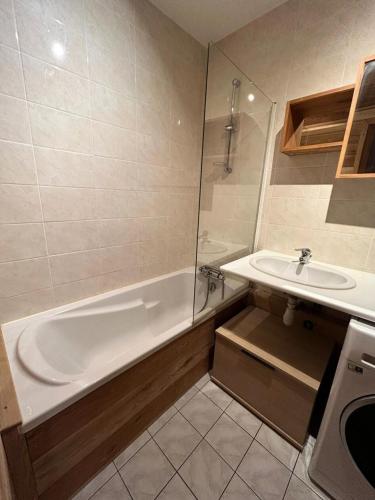 une salle de bain avec une baignoire et un lavabo dans l'établissement Résidence Les Arolles - 2 pièces cabine 6 personnes exposé Sud MAE-9724, à Valloire