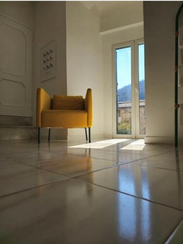a yellow chair in a white room with a window at Sathicula B&B in SantʼAgata deʼ Goti