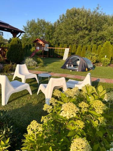 a group of white chairs and a tent in a yard at Sielanka Chwaliszów dom całoroczny in Chwaliszow