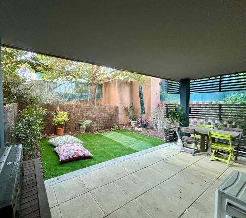 d'un petit jardin avec une table et une pelouse. dans l'établissement Le petit Cosy Aixois, à Aix-en-Provence