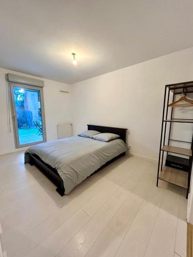 une chambre avec un lit et une grande fenêtre dans l'établissement Le petit Cosy Aixois, à Aix-en-Provence