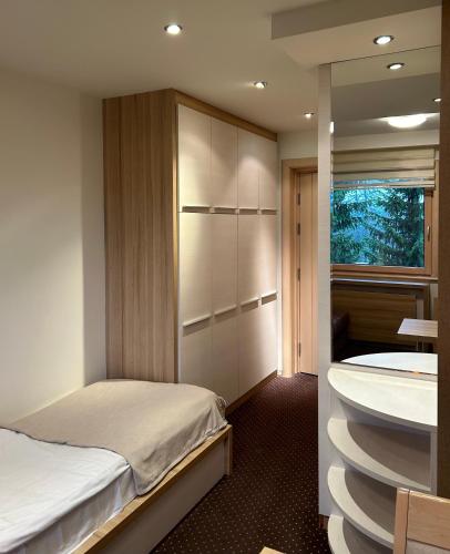 a bedroom with a bed and a tub and a sink at Apartmani Haski Konaci in Kopaonik