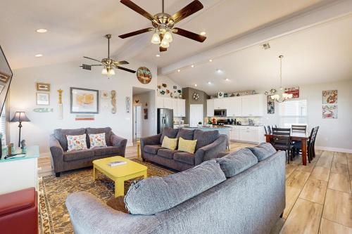 Una sala de estar con dos sofás y una cocina. en Beautiful Sea, en Port Aransas