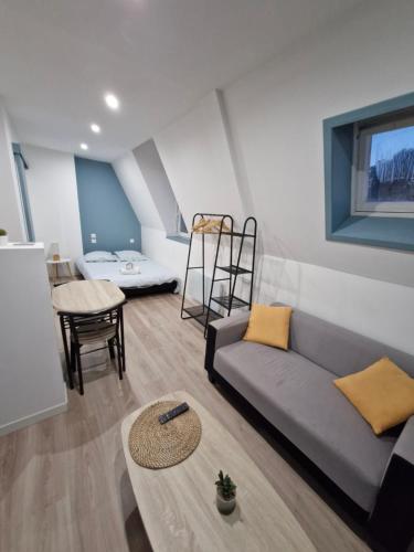 un salon avec un canapé et une table dans l'établissement Studio Canada 5, à Valenciennes