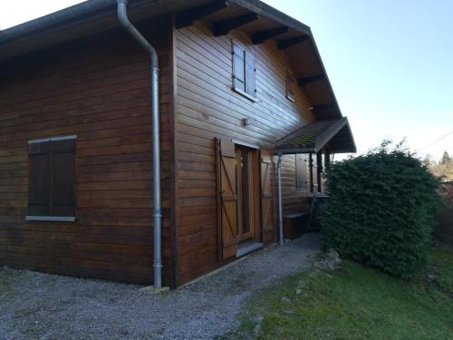 Chalet de la Lette في فينترون: مبنى خشبي به باب وشجيرة