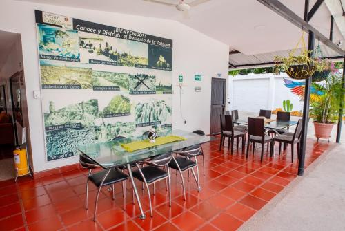 a dining room with a table and chairs and a large poster at Hotel Villa Paraiso in Villavieja
