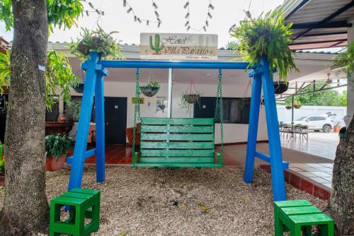 a swing in front of a restaurant with plants at Hotel Villa Paraiso in Villavieja