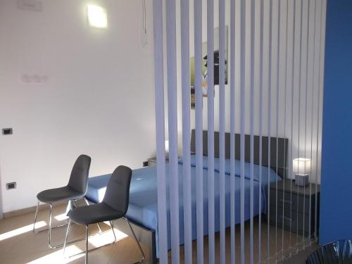 a bedroom with a blue bed and two chairs at Maria Teresa's Large Open space indipendent in Cardedu