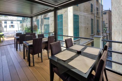 a patio with tables and chairs on a balcony at Hotel Doria in Genova