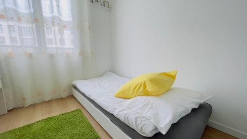 - un lit avec un oreiller jaune dans l'établissement à Paris, à Montrouge