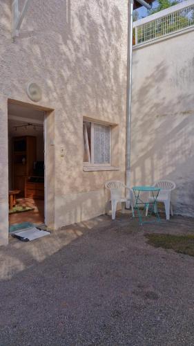 une table et deux chaises à côté d'un bâtiment dans l'établissement Appartement F1 à la campagne, à Cruseilles