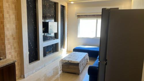 a living room with a table in the middle of a room at Izz AlDin Tamimi St شقة مفروش سوبر ديلوكس الجبيهة in Ţāb Kirā‘