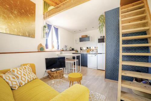Una sala de estar con un sofá amarillo y una cocina. en Maisonnette en pleine Campagne LA K-LINE, en Entrecasteaux