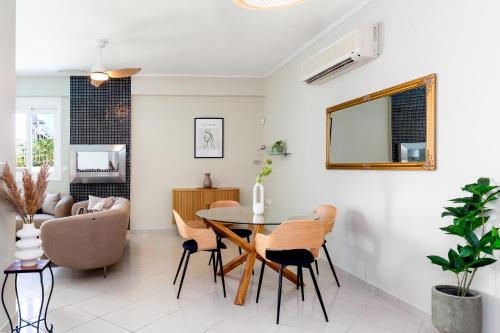 a dining room and living room with a table and chairs at Helios Residence by A&D Properties in Porto Rafti