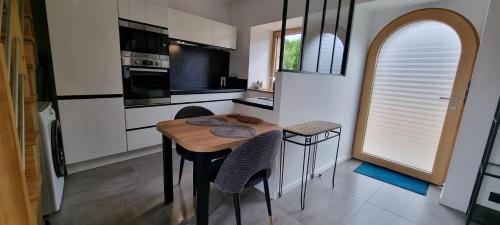 une cuisine avec une table et des chaises dans une cuisine dans l'établissement San Erwoan, à Perros-Guirec