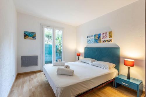 une chambre avec un grand lit blanc et une fenêtre dans l'établissement LB Vacation Rentals I Spacious 2BR Apartment with Terrace, Balcony, à Mougins