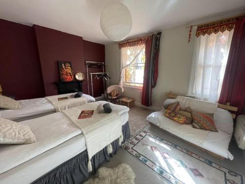 a bedroom with two beds and a couch at Glastonbury 2-Bed House Sleeps 6 & Pet Friendly in Glastonbury