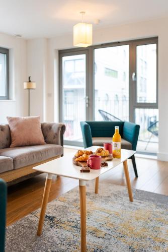 a living room with a coffee table with food on it at Chic property near Tower Hill with a gym in London